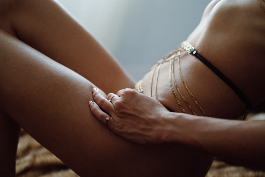 close up photo of a woman's mid section with a delicate gold body chain